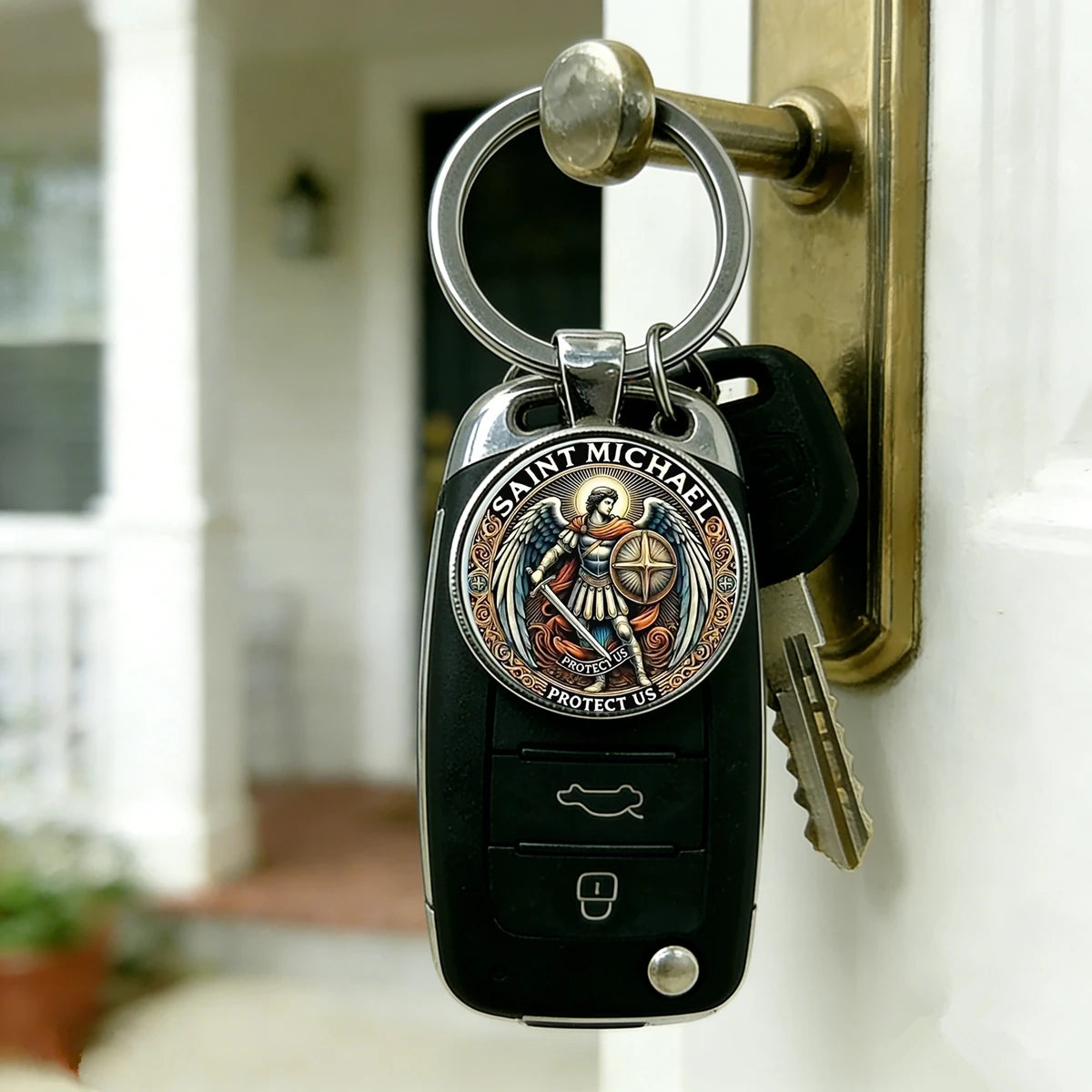 A black key chain featuring a medallion of Saint Michael the Archangel for protection, hanging on a door.