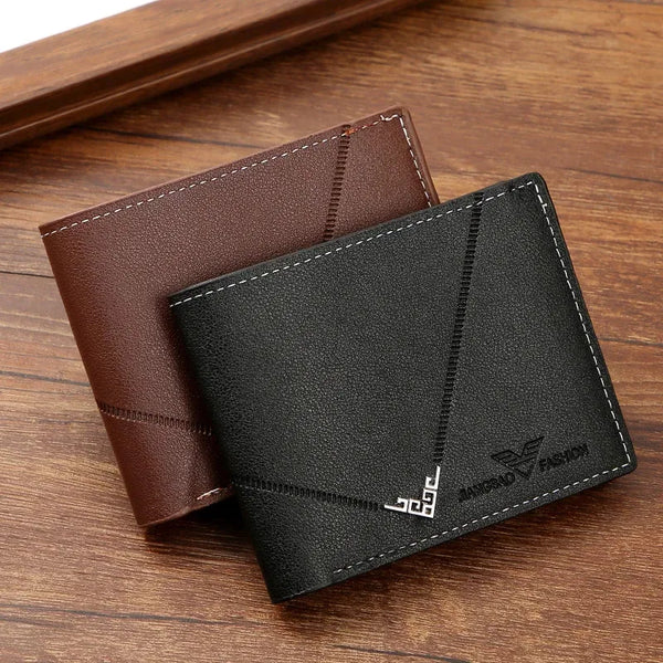 A dark gray leather bifold wallet with a black sleeve and a visible logo is shown on a wooden surface.