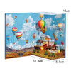 A wooden 3D puzzle book shelf insert kit depicting a colorful magic house scene with balloons in a blue sky.