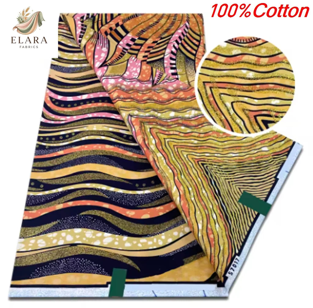 A close-up view of a yellow and orange African wax print fabric with swirling patterns.