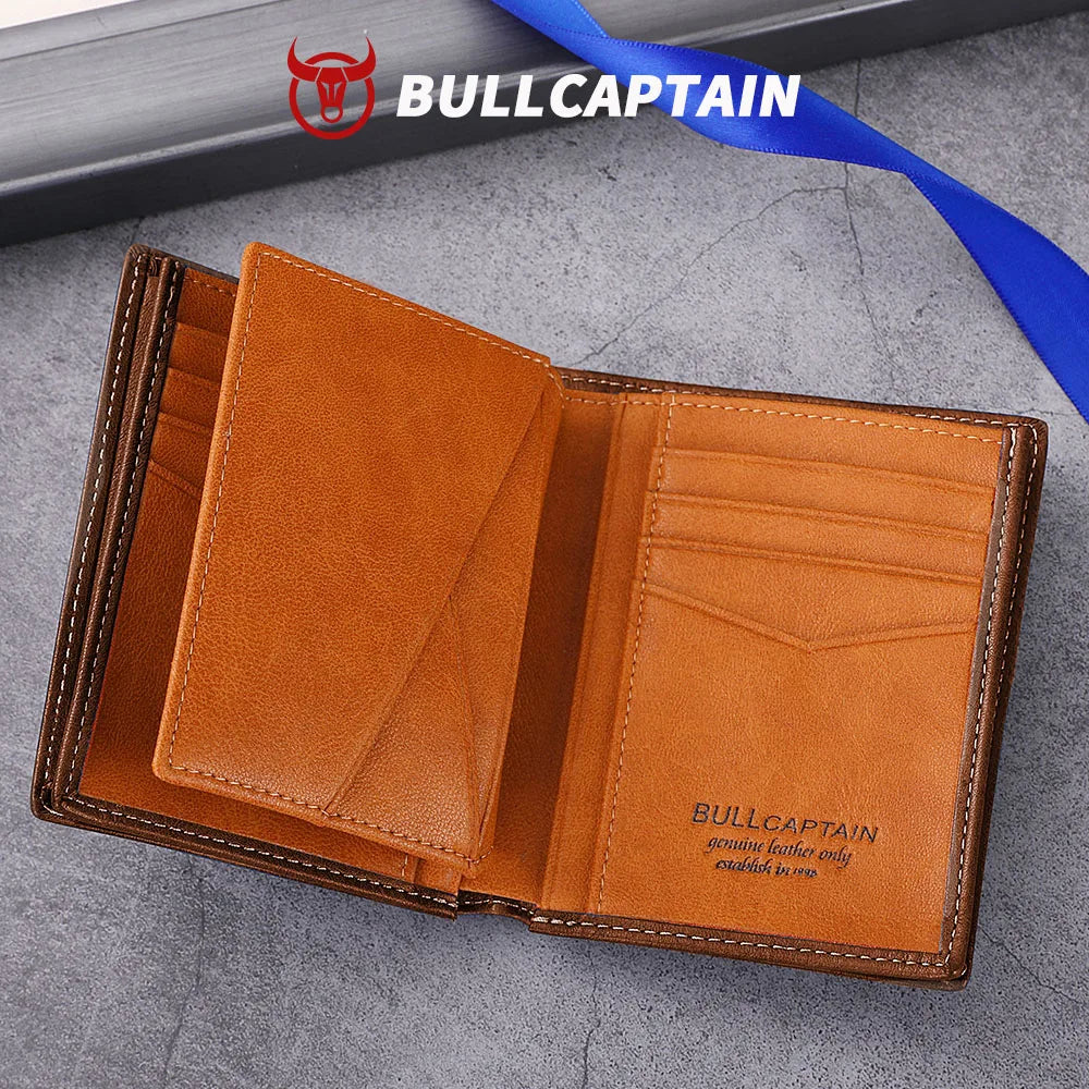 A brown genuine leather men's bifold wallet with stitching shown open on a gray surface.