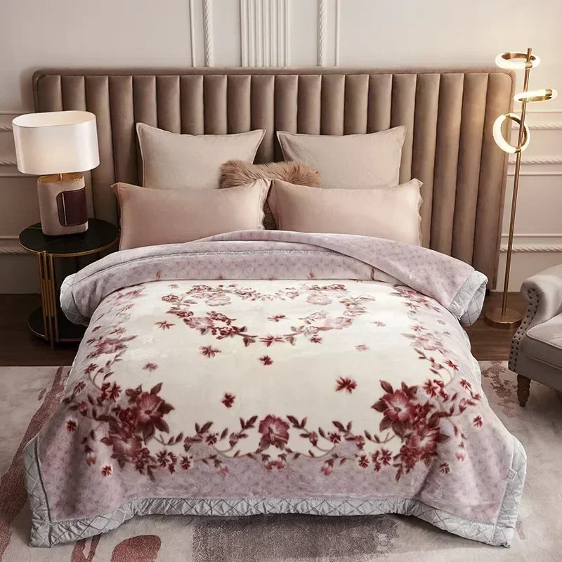 A beige weighted plush blanket with a floral pattern is displayed on a bed in a light-colored room.