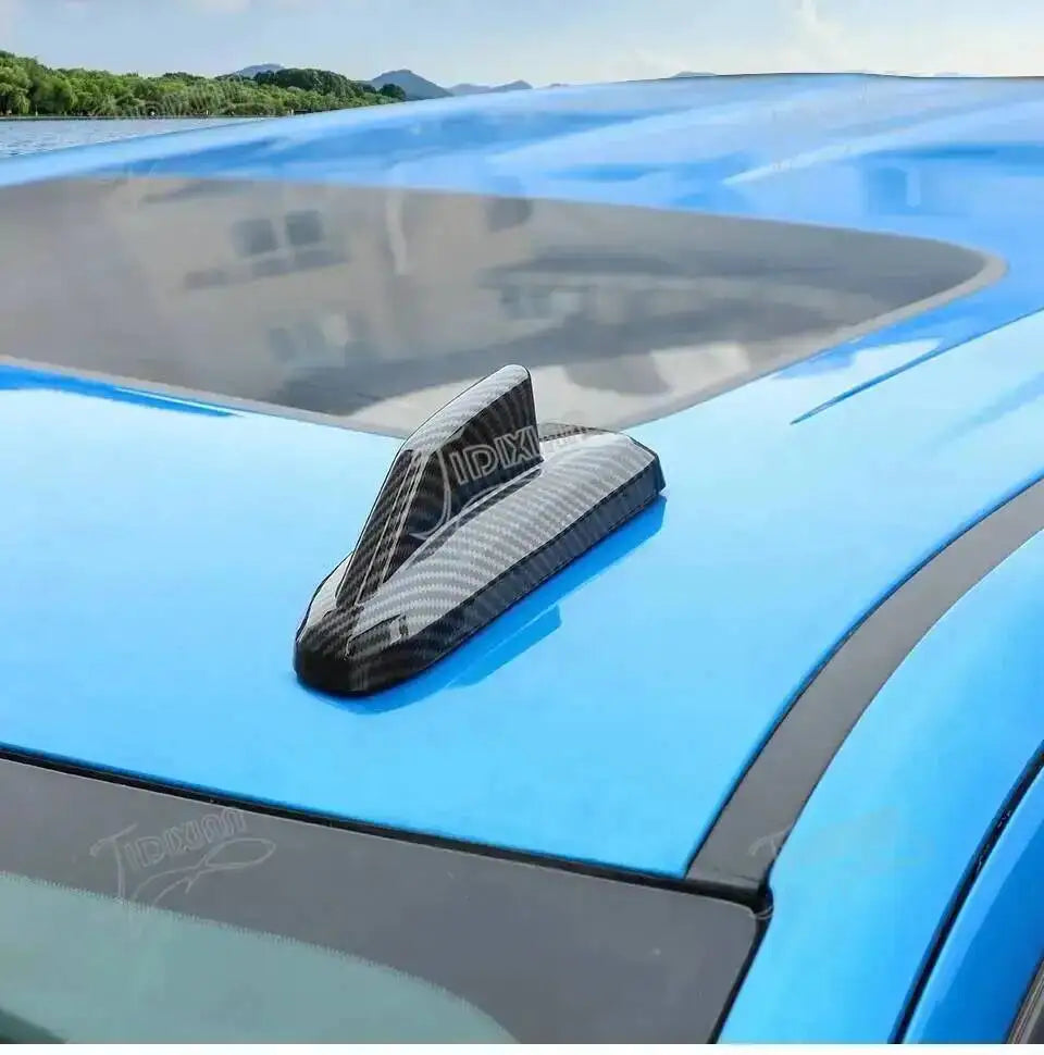Blue car antenna cover trim installed on a vehicle roof, featuring an IDX logo.