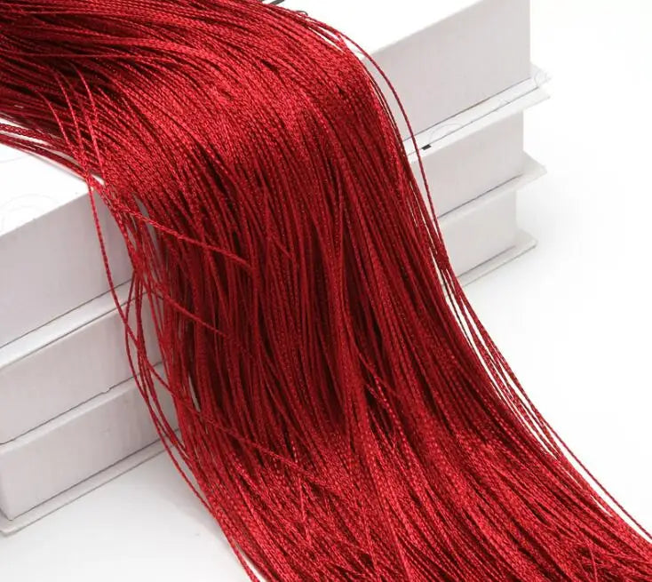 A close-up of a long, vibrant red beaded thread curtain hanging down.