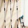 Three black and orange foldable grabber reachers displayed vertically against a light wall.
