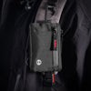 Black RFID-blocking travel wallet attached to a jacket with a carabiner clip.