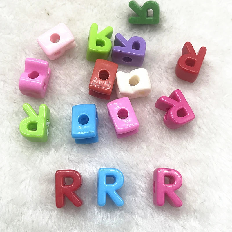 A collection of 10 mixed alphabet letter beads in various colors including pink, green, purple, and red.