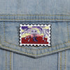 A vintage airline ticket enamel brooch featuring a skull and crossbones design on a denim shirt pocket.