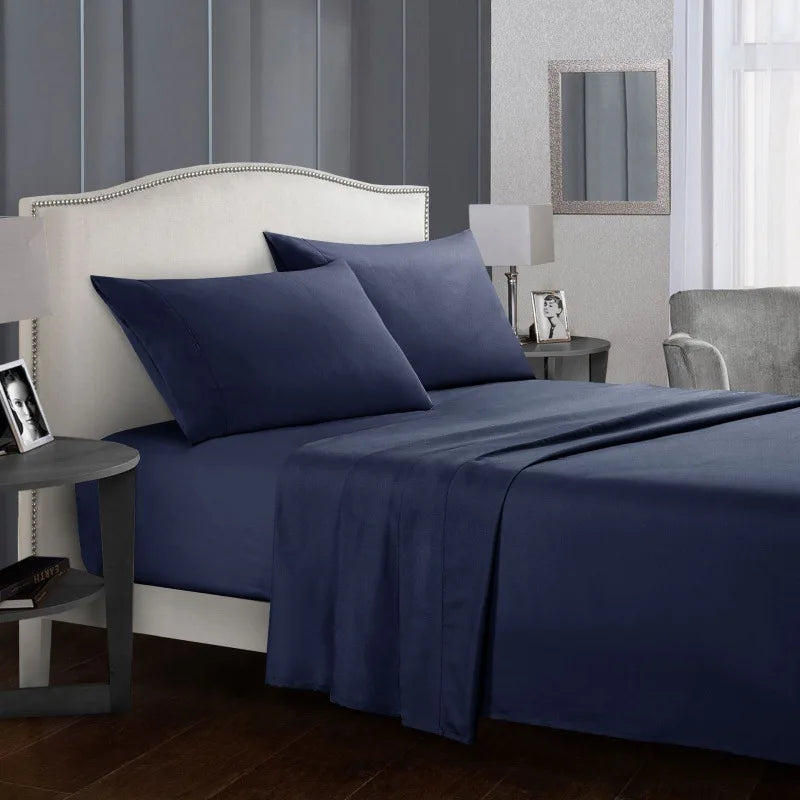 Un lit bleu marine avec tête de lit et literie blanche dans une chambre.