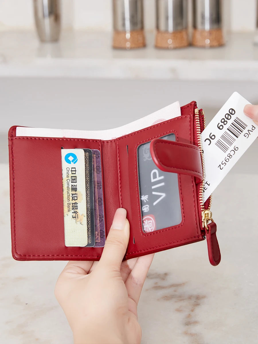 A red PU leather bifold wallet with a gold zipper and an ID card visible inside, held by a hand.