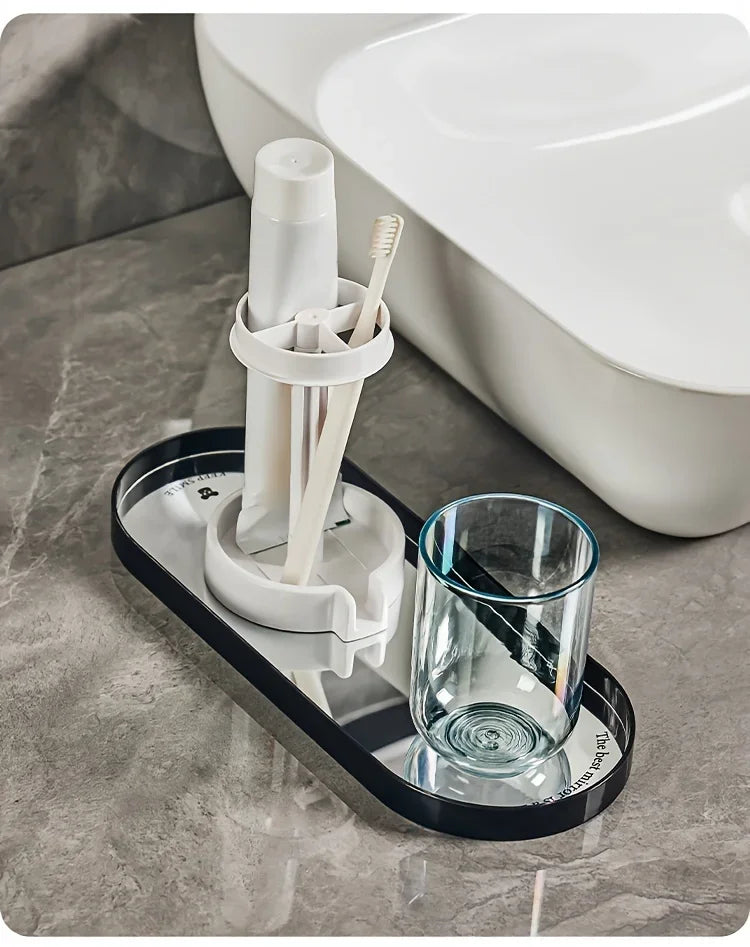 A modern bathroom toothbrush holder with a dust cover and drainage is placed on a black tray next to a toilet bowl.
