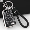 A silver TPU car key fob cover with a black strap is shown against a dark background.