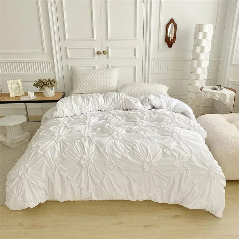 White luxury duvet cover set featuring a 3D twist floral pinch-pleated design on a bed.