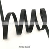 Black satin ribbon coiled and laid out against a white background