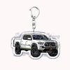 A silver metal key ring attached to a miniature model of a white off-road pickup truck.