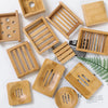 A collection of wooden bamboo soap dishes and trays with various drainage patterns.