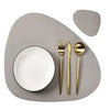 A set of reusable placemats and cutlery displayed on a neutral gray plate.