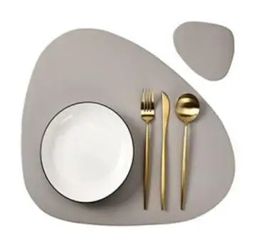 A set of reusable placemats and cutlery displayed on a neutral gray plate.