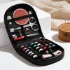 A black compact travel sewing kit with various tools including scissors needles and thread spools is displayed on a white sur
