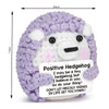 A handmade crochet hedgehog doll with purple and white fur, featuring a card that says Don't let prickly things in life get y