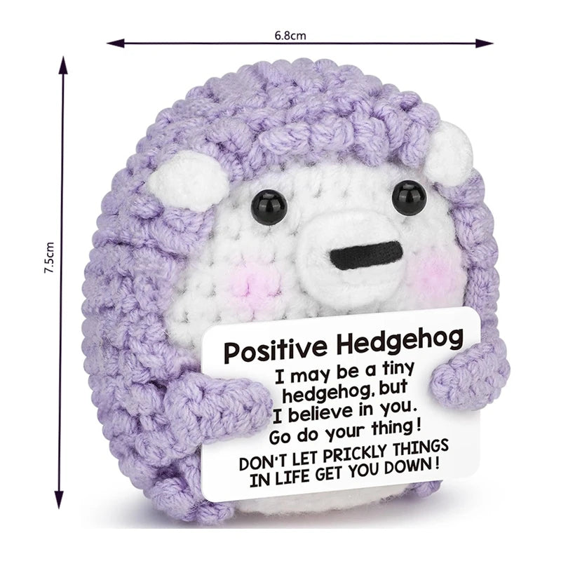 A handmade crochet hedgehog doll with purple and white fur, featuring a card that says Don't let prickly things in life get y