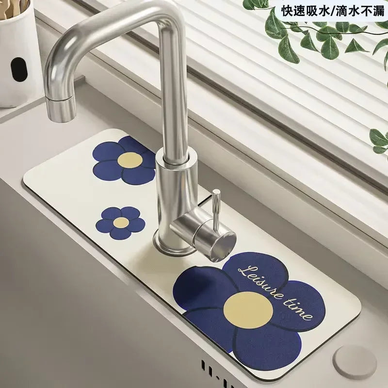 A modern chrome faucet mounted on a white mat decorated with blue and yellow floral patterns.