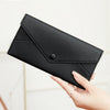 A hand holds a black slim RFID-blocking PU leather wallet with card slots.