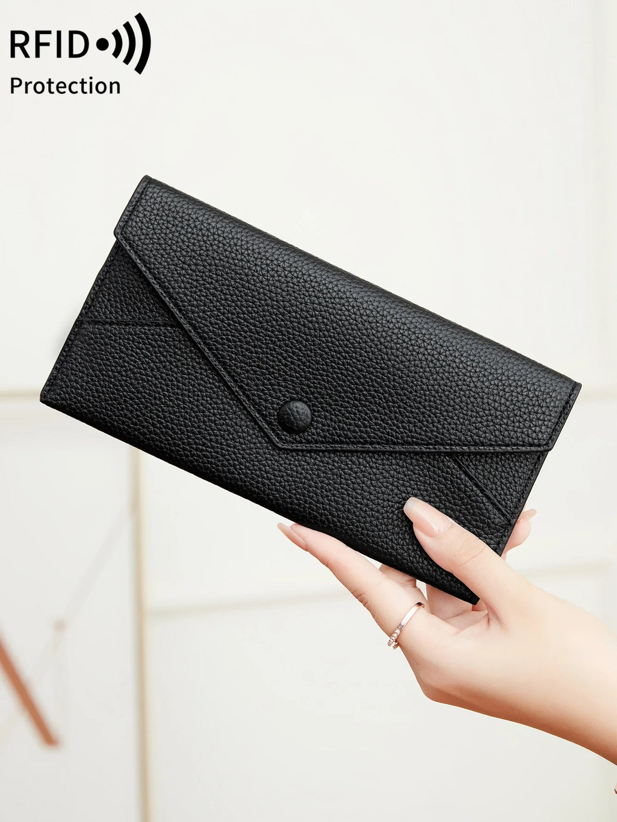 A hand holds a black slim RFID-blocking PU leather wallet with card slots.