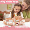 A young girl and woman are setting up a mini dollhouse furniture set for pretend play.