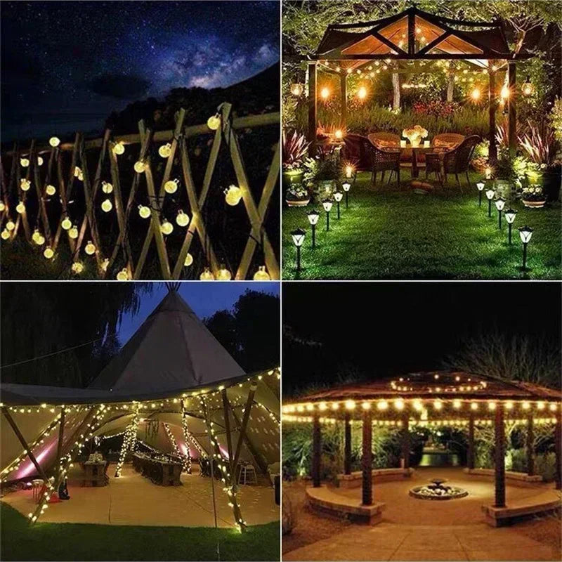Outdoor fairy lights strung across a wooden fence and draped over a rustic outdoor dining area at night