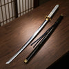 A replica Yamato sword, resembling a Vergil Katana from Devil May Cry 5, is displayed on a wooden surface.