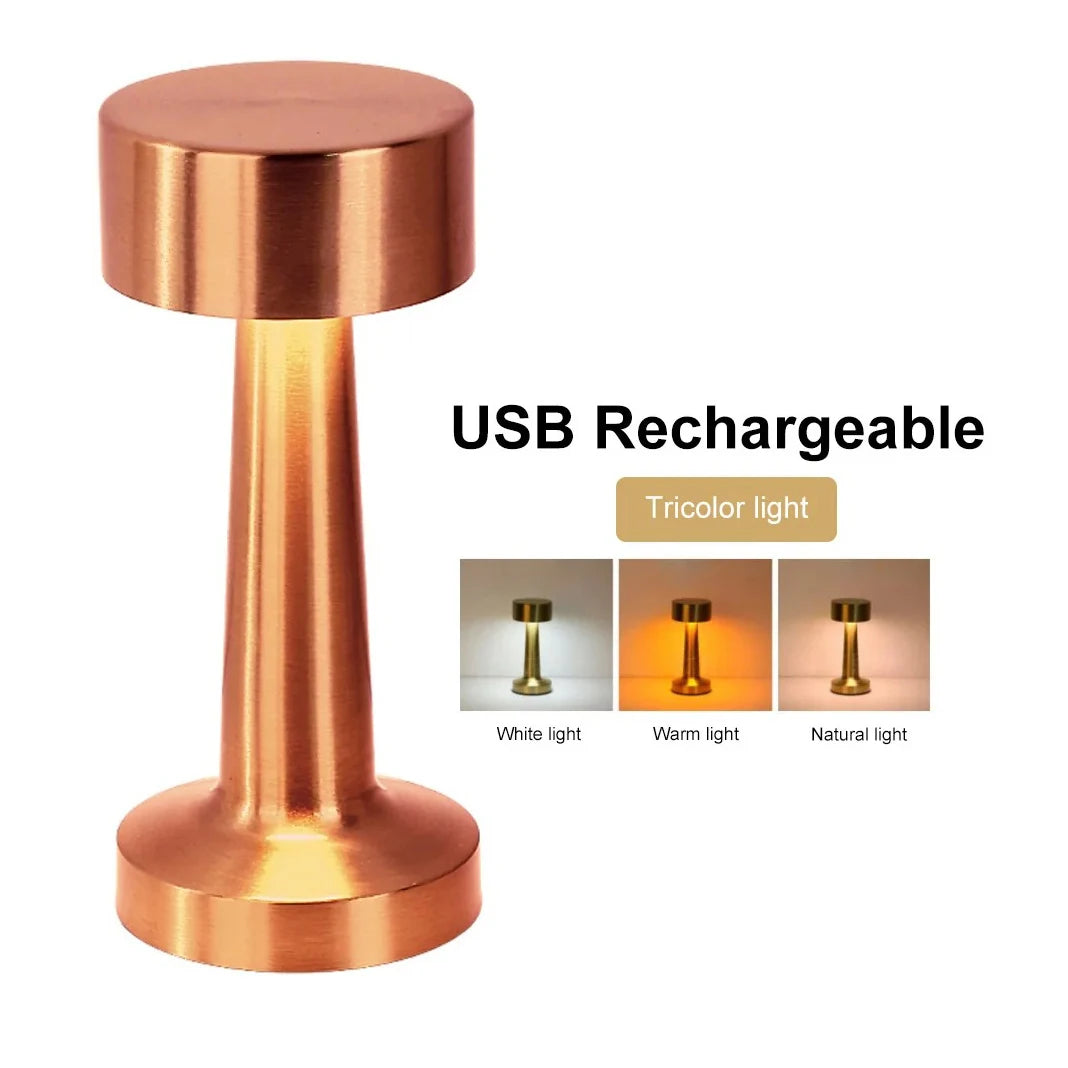 A rose gold metal rechargeable USB LED table lamp with a tripod base and light options.