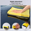 A yellow microfiber cleaning towel soaking up water in a basin.