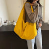 A person is holding a bright yellow lightweight nylon tote bag with a secure zipper closure.
