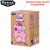 A pink Fuggler bear plush keychain with a rainbow detail is shown in its packaging box.