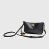 A black classic leather tote bag with a gold metal buckle and black strap.