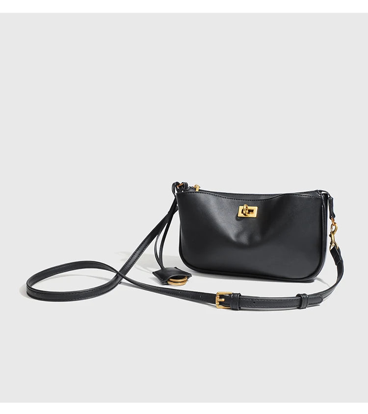 A black classic leather tote bag with a gold metal buckle and black strap.
