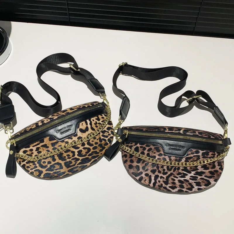 A leopard print waist bag with black straps and gold hardware is displayed on a white surface.