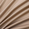 Close-up of a beige luxury bamboo flat sheet fabric draped in soft, flowing folds.