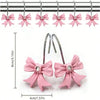 A set of twelve pink decorative bow tie shower curtain hooks with silver hangers.
