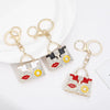 Gold-toned crystal rhinestone handbag keychain with a square design and a gold split ring.