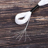 A bundle of white embroidery floss with a black tip is laid on dark wooden surface.