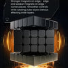 A close-up view of a black magnetic cube with an orange glow, demonstrating its internal magnetism and construction.