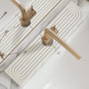 A brass faucet mat with concentric grooves is installed on a white countertop.
