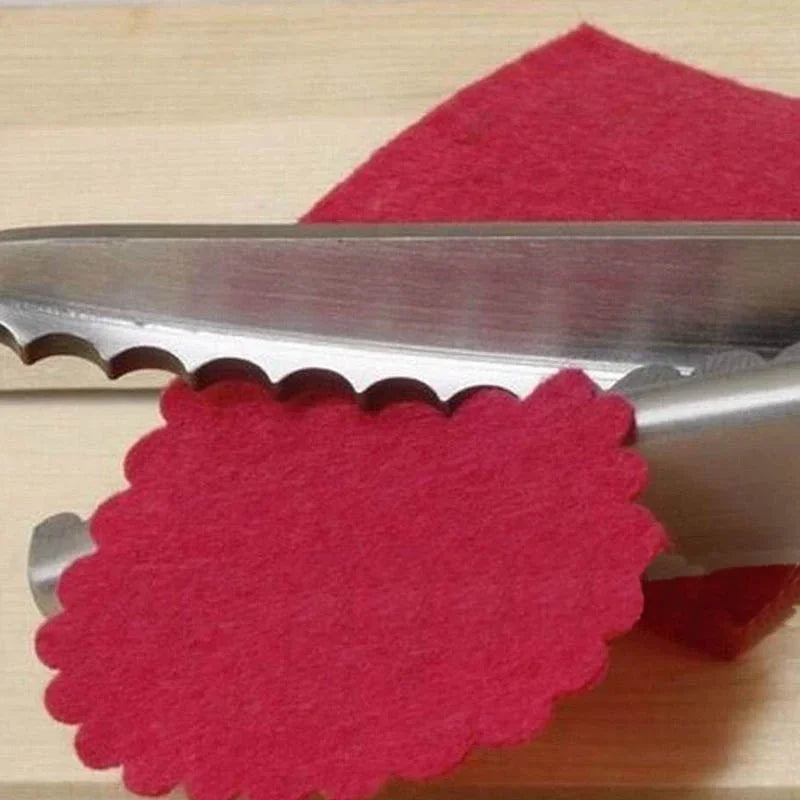 A pair of professional stainless steel serrated lace scissors with red felt material visible.