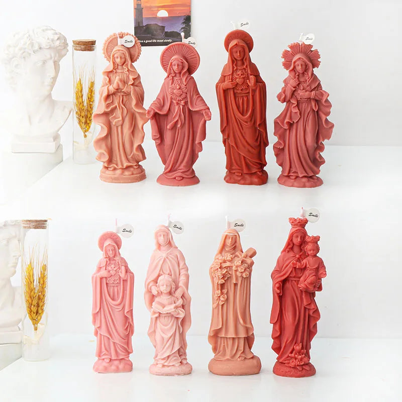 A collection of pink terracotta-colored 3D silicone molds depicting various religious figures for candle and resin crafting.