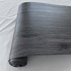 Roll of dark gray wood grain peel and stick wall decals