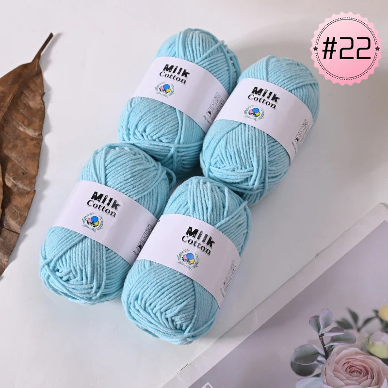 A stack of light blue milk cotton yarn skeins for knitting and crochet projects.