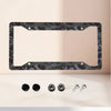 Aluminum license plate frame with a black and grey camouflage finish displayed on a light surface.