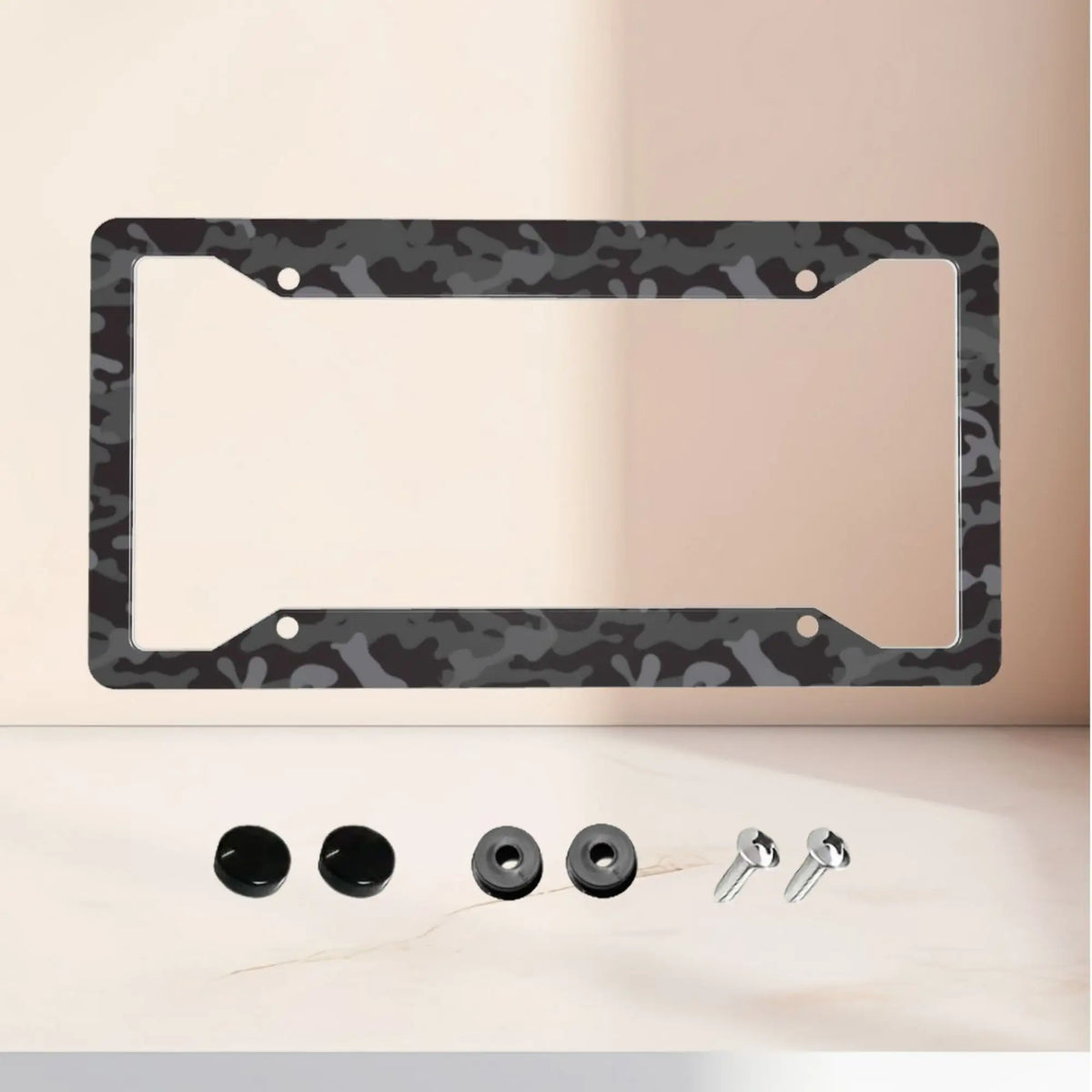 Aluminum license plate frame with a black and grey camouflage finish displayed on a light surface.